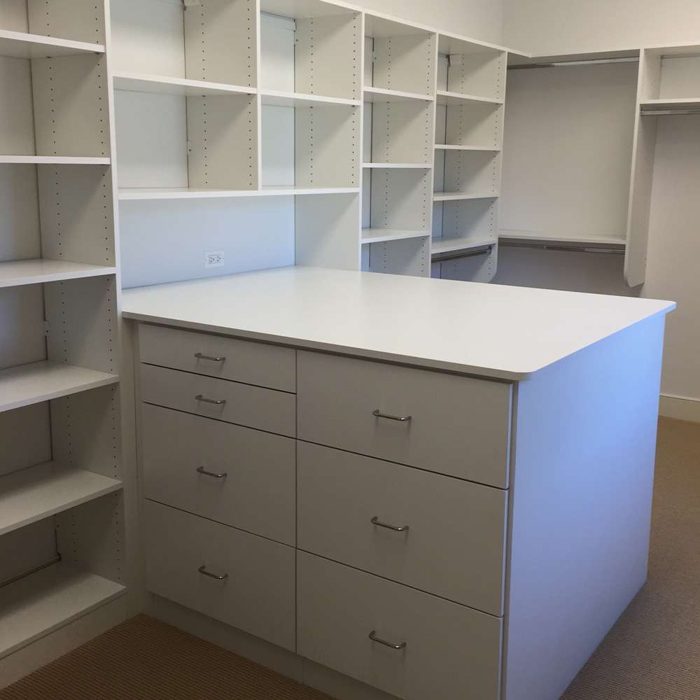 White melamine with Flat fronts, standard chrome handles, and walk-in closet with peninsula