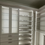 Illuminated Primary Closet with Glass Accents